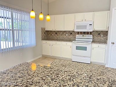 Large kitchen with granite counters and an equally large kitchen pantry.