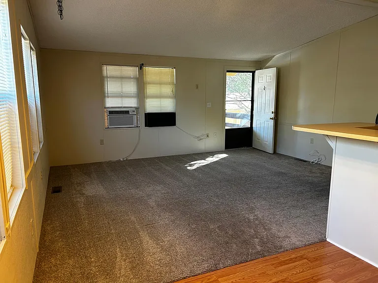 Living room, front door, supplemental window a/c. Snack bar on right side