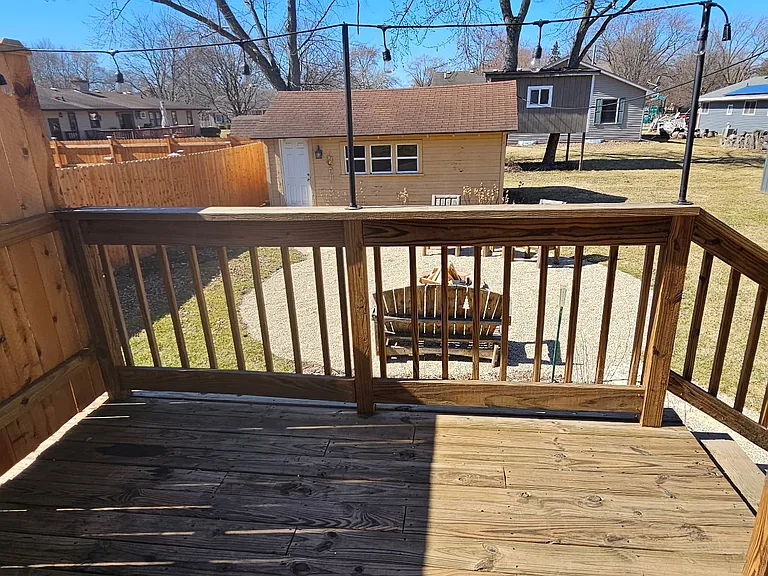 Patio deck overlooking fire pit area and backyard