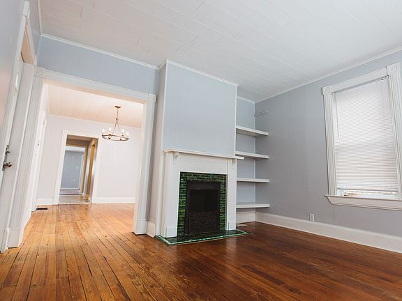 Front room with decorative fireplace with original green tile