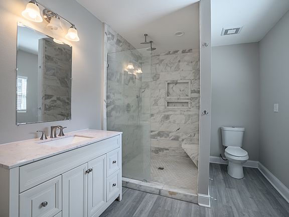 Bathroom with large marble shower, dual shower heads and 4 foot vanity.
