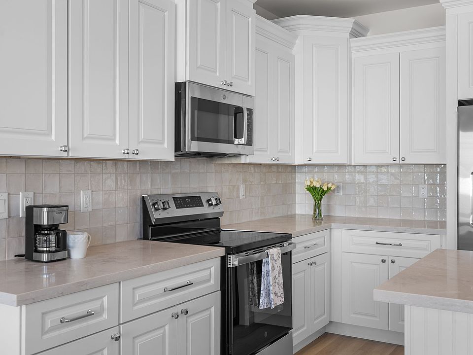 Designer cabinetry with soft-close doors and drawers, stainless steel appliances, and gorgeous quartz countertops