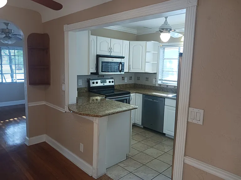 Partial views of kitchen, dining area, and living room from front of Florida room.