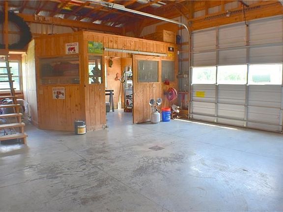 A small section of the detached garage includes workshop/office and stairs to more storage!