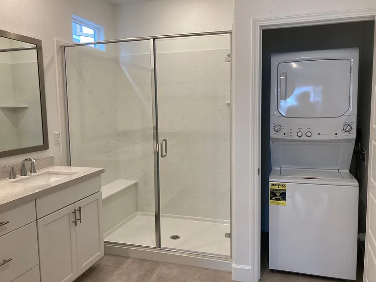 In-Law bath with stacked washer dryer in closet.