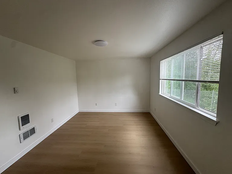 Sun-filled primary bedroom with large windows that bring in abundant natural light throughout the day.
