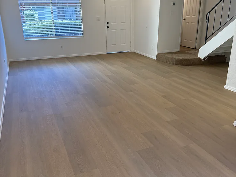 Living room showing entry door, powder bath and stairs to upstairs