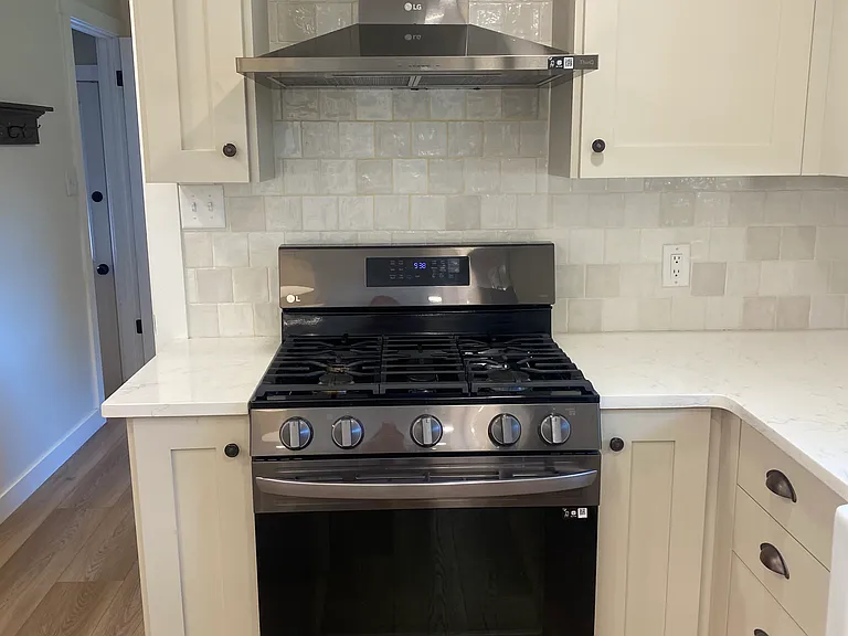 Beautiful stove with hood. Amazing tile backsplash.