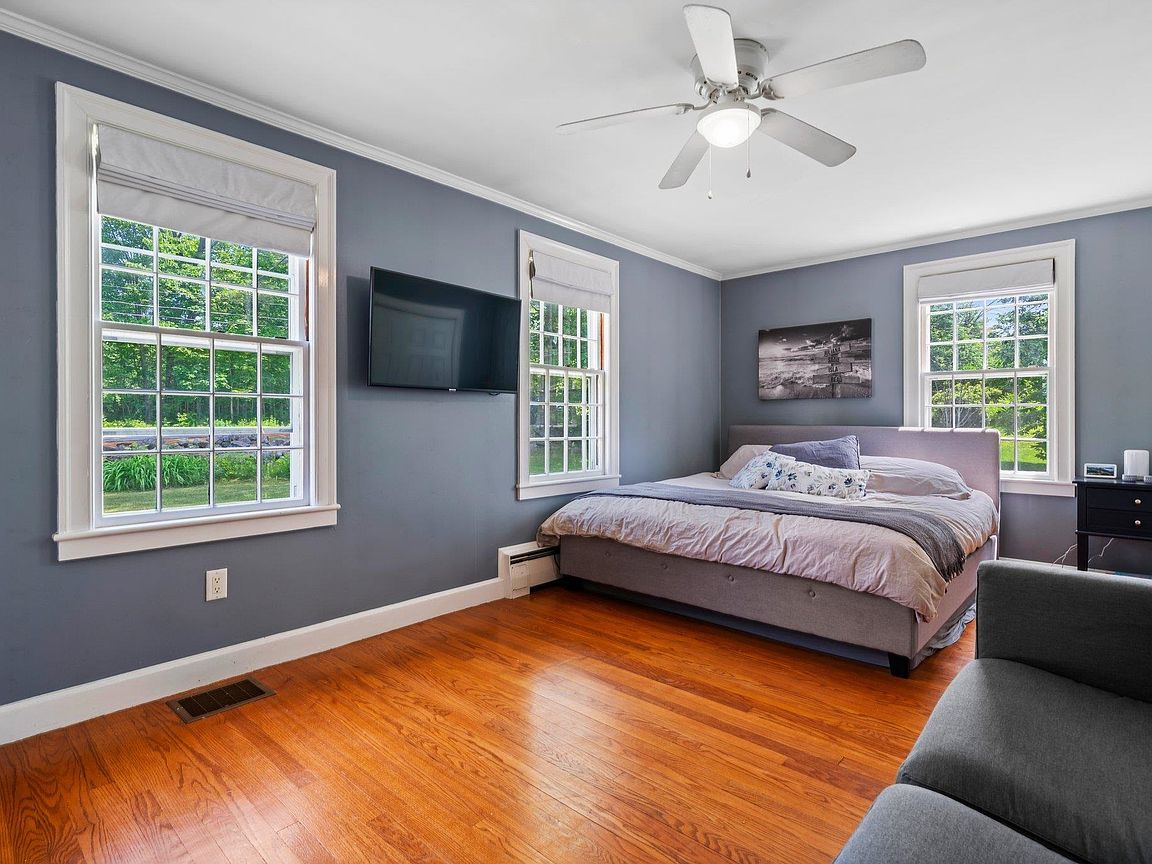 Spacious bedroom with hardwood floors and large windows at 26 Garrison Lane, Hopkinton NH