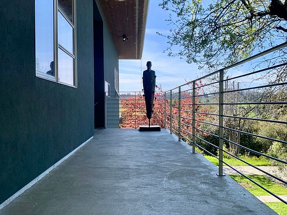 A few steps up to walkway to front door. The guardian sculpture welcomes you.