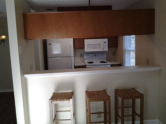 Galley kitchen with eat in bar open to living room