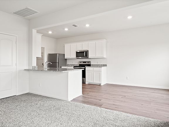 The kitchen of the Cypress has beautiful white wood cabinets.