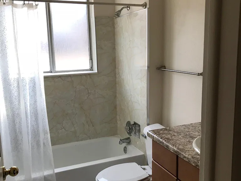 There is a curtain on the window made out of a shower curtain. The bathroom is deeper than it looks. There are 6 large tiles between the doorway & the tub.