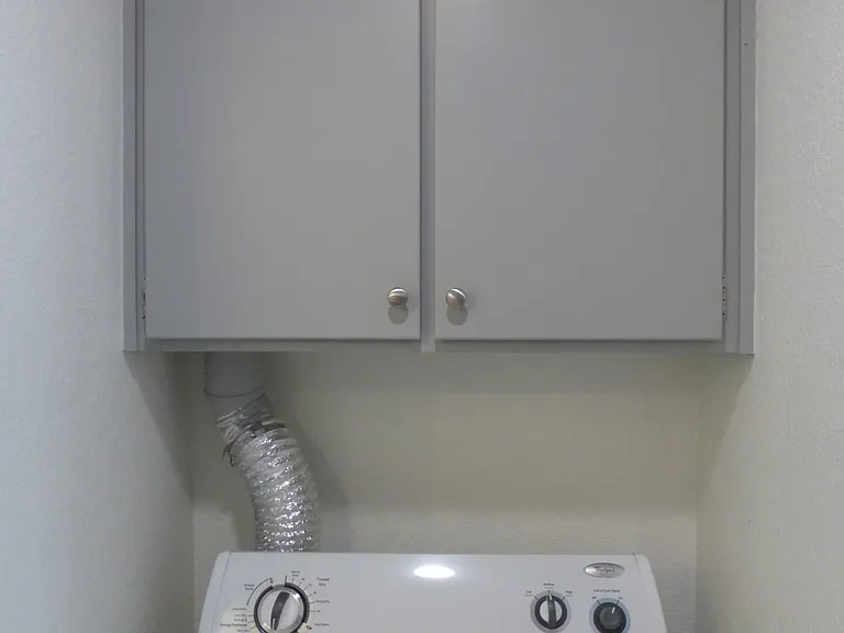 Dryer and cabinet above for more storage space.
