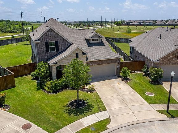 A front aerial shows an extended driveway offering plenty of parking for all who visit!