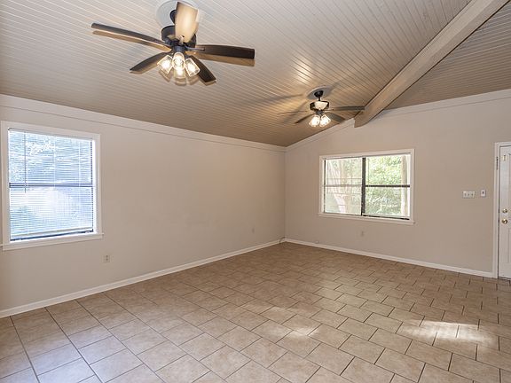 Another view of living room sowing vaulted ceiling.