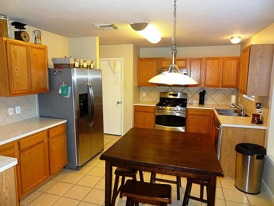 Very open kitchen with stainless steel appliances and breakfast area, tile flooring and back splash.