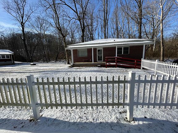 Front of the cottage with fence enclosing a portion of the yard