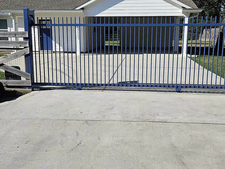Electric gate with keypad and gate opener / carport view.