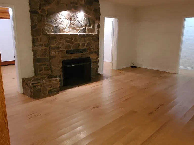 Living room with fireplace. Doors lead to family room and hallway to bedrooms.