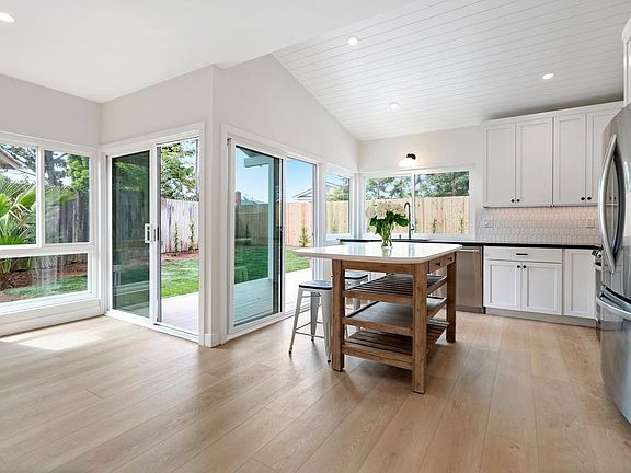 Bright, sunny kitchen and family/dining room with island, vaulted shiplap ceiling, quartz countertops, all new high-quality appliances. New windows throughout and sliding glass doors to deck for indoor/outdoor living.