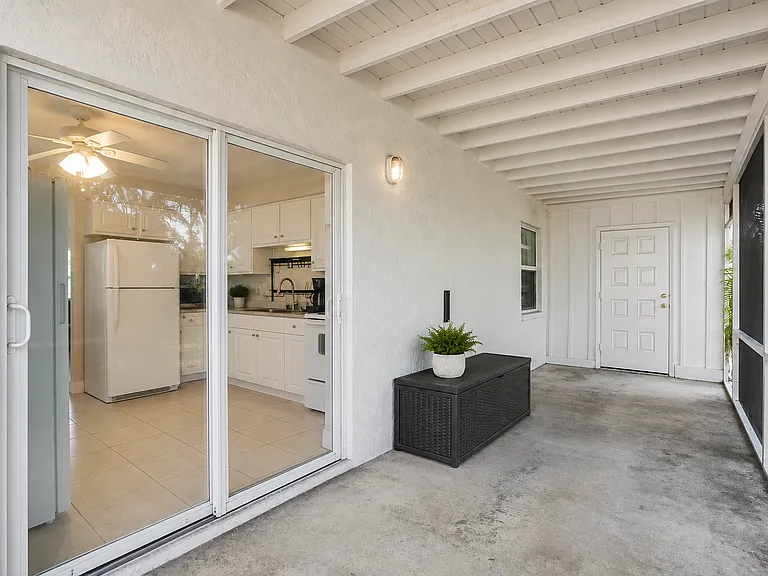 The screened lanai offers a peaceful outdoor retreat with views of the spacious backyard, perfect for morning coffee, evening relaxation, or enjoying the Florida breeze bug-free