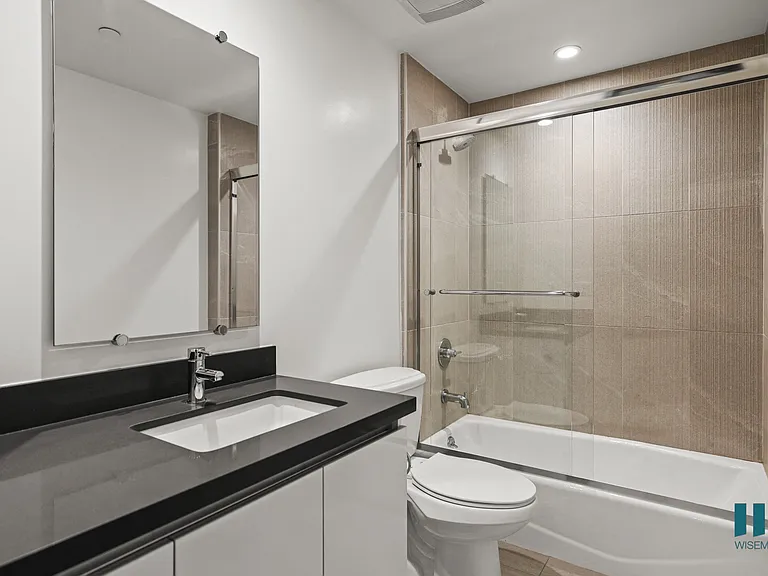Bathroom with Bathtub with Glass Door and Vanity Cabinet Storage