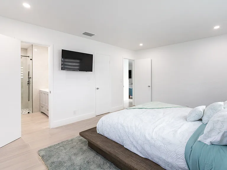 master bedroom with bathroom ahead and entrance out to the hallway