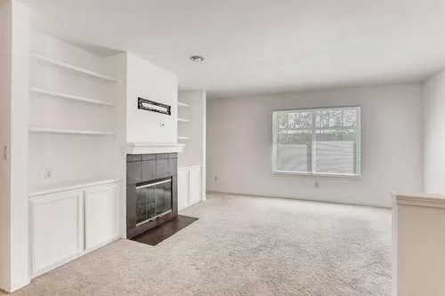 Living room with gas fireplace and lots of shelving. Tons of light. - 12711 35th Ave NE #B