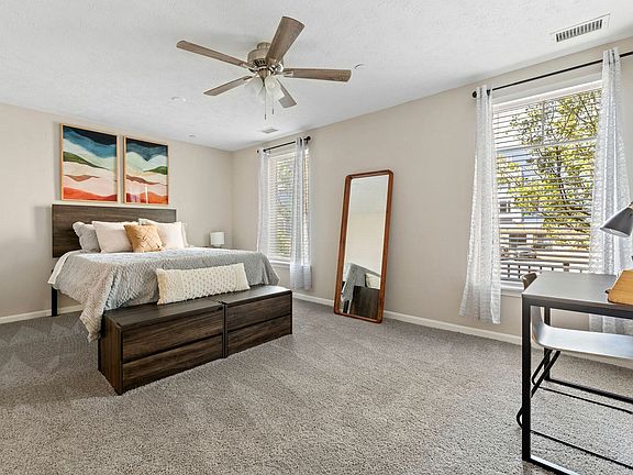 Relax in a serene bedroom with premium carpet and ceiling fan for ultimate comfort in downtown Akron