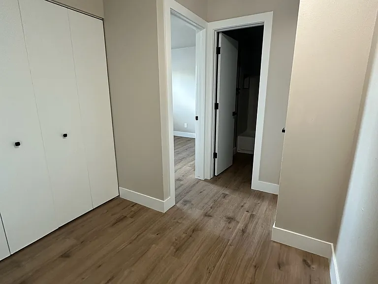 Upstairs hallway with laundry on the left, and secondary bedroom in the back.