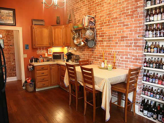 Eat in Kitchen (built in floor-ceiling shelving, bright, exposed brick