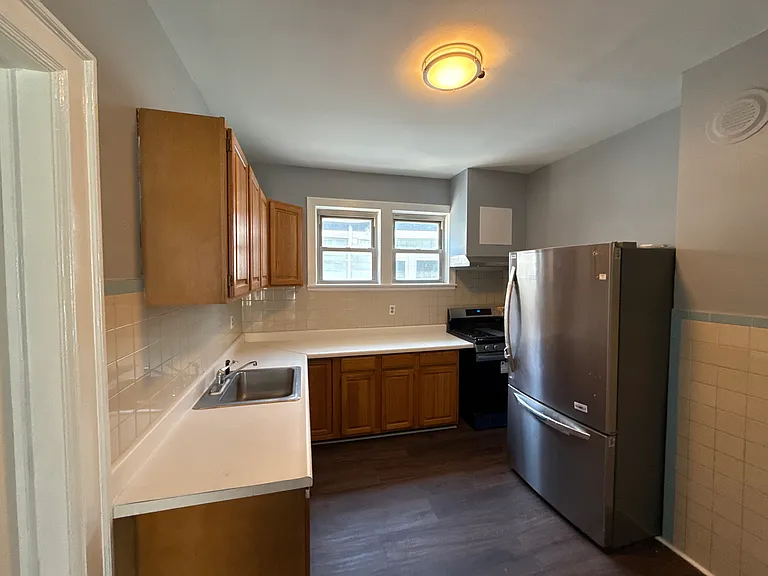 Kitchen with refrigerator, gas oven stove and range hood
