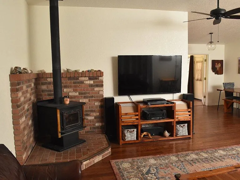 Wood stove and entertainment system in living room.
