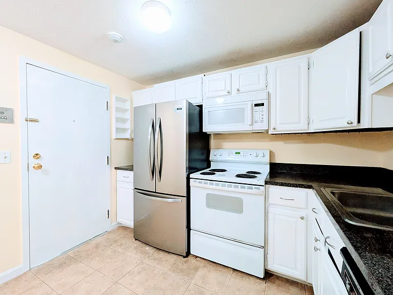 Kitchen with a new fridge and a newer microwave, range, and a dishwasher