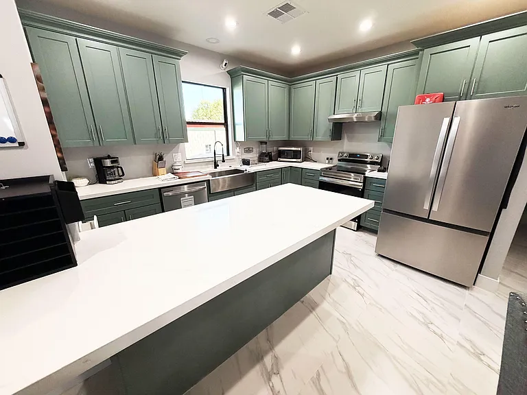 Spacious U-shaped kitchen with a large island, ample cabinet storage, and stainless-steel appliances for everyday cooking