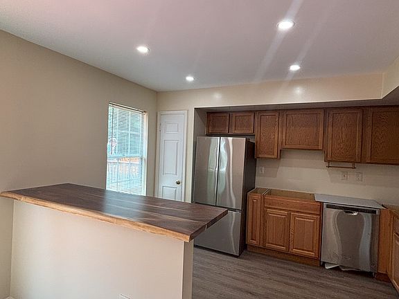 Kitchen with a tall pantry and a large window