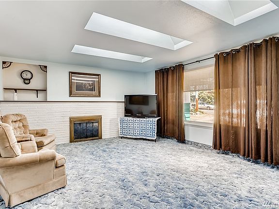 The living room boasts of a warm fireplace, skylights and a large picture window.