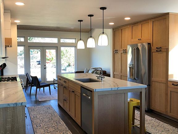 View of kitchen from dining room, looking through to living room and backyard