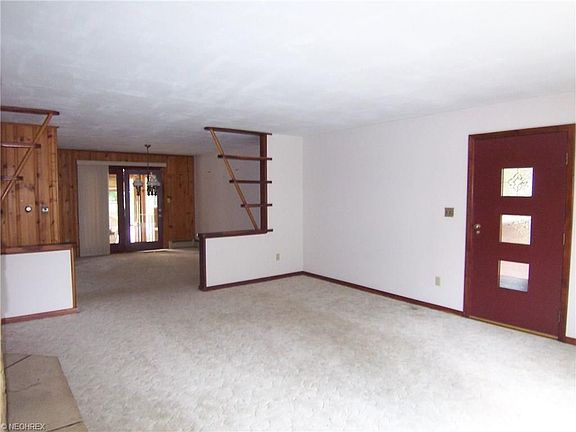 Living room with front door entrance and view to dining area