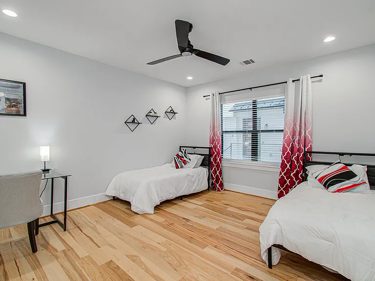 Versatile third bedroom featuring two twin beds and a dedicated workspace, perfect for remote work, studying, or accommodating additional guests.