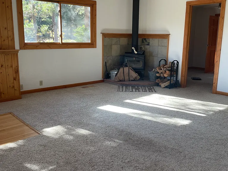 Wood stove in living room, entrance to main bedroom pictured on right
