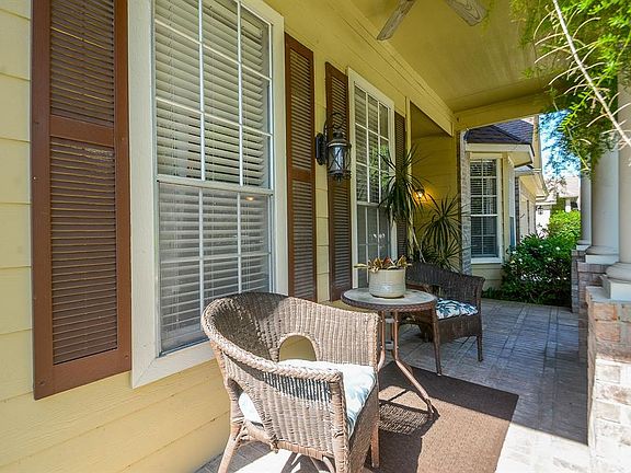 Enjoy a morning cup of coffee with the birds chirping on your quaint front patio deck. This is the view from the left side of the house, looking across the porch toward the front door.
