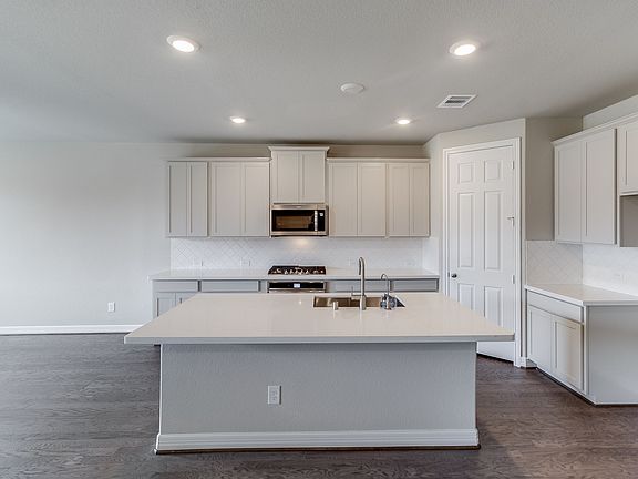 This kitchen is a chef s dream The kitchen features light cabinetry with quartz countertops and a
