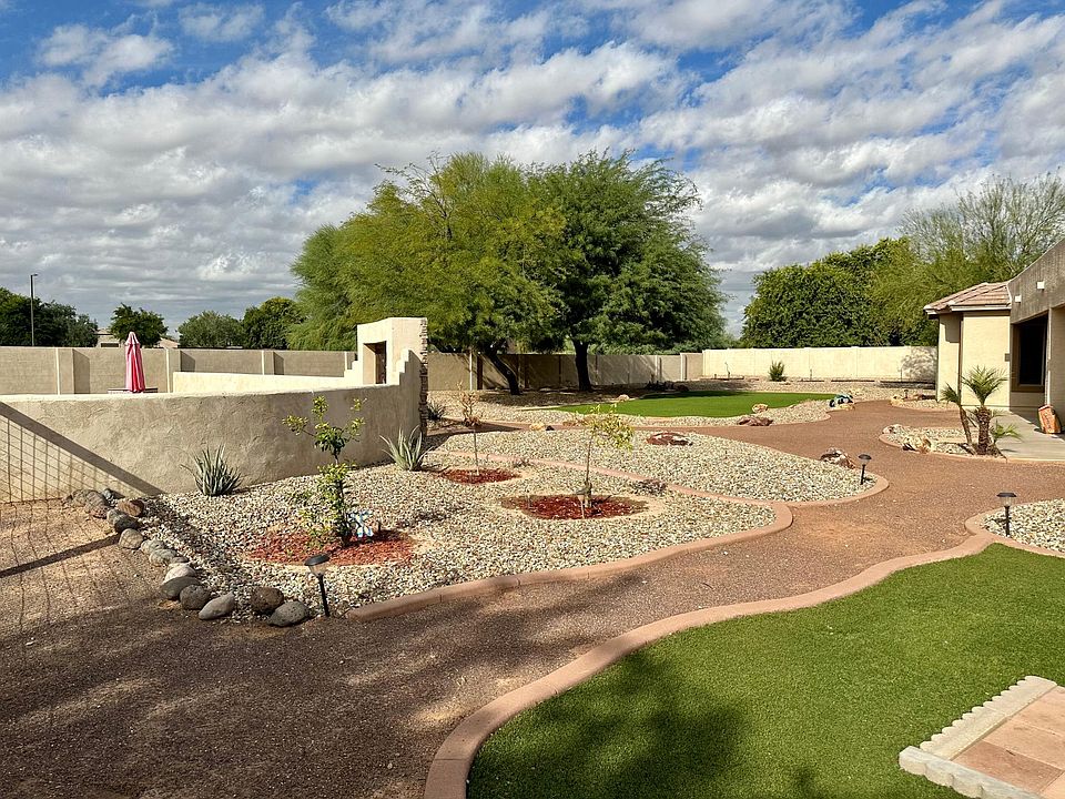 Enjoy this extra-large low-maintenance yard. Includes two areas of artificial grass (no watering needed), a firepit, enclosed garden with raised beds, and a large swimming pool, great for cooling off in out hot Arizona summers!