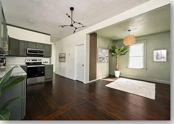 Spacious living room adjoins kitchen with new brushed stainless-steel appliances and gorgeous cabinetry.