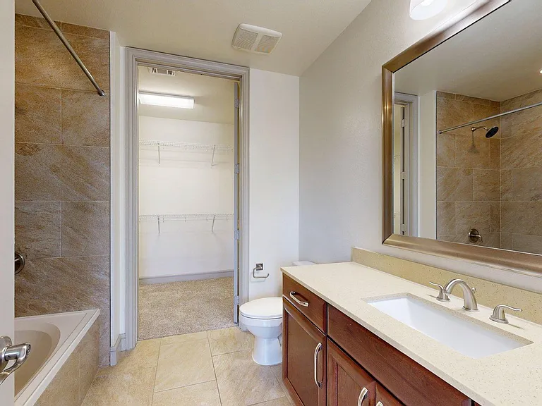 Griffis Uptown apartment bathroom with soaking tub and mirror.