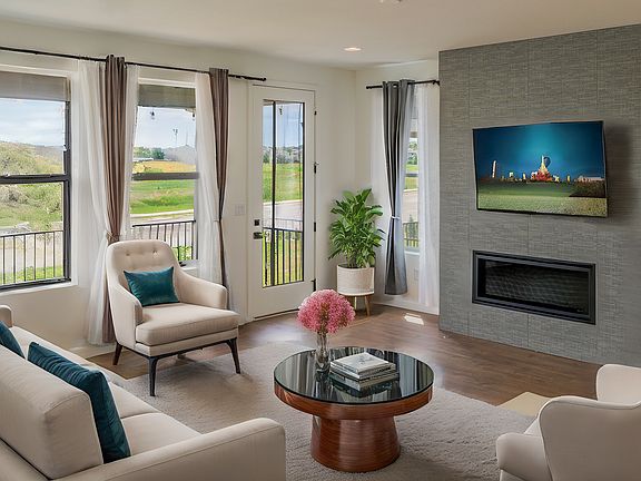 Comfortable living room featuring a central fireplace and natural light