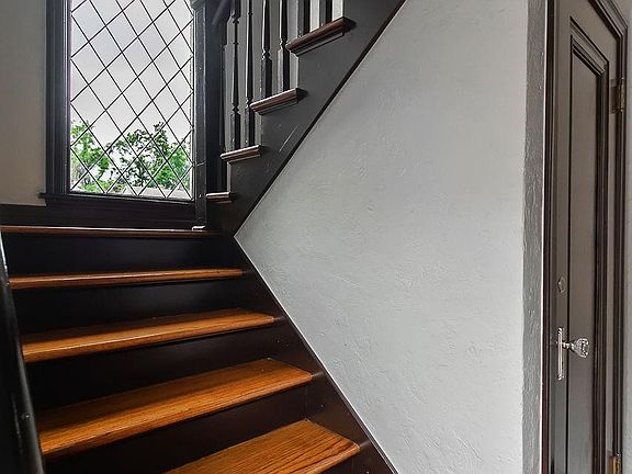 The staircase to the upstairs unit features the original window that highlights the entry. A large closet is at the base of the stairs.