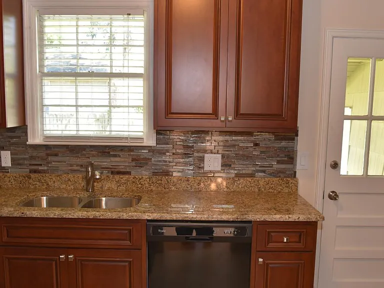 Mosaic glass tile backsplash, granite counters, under-cabinet LED lights, Moen sprayer/faucet, customer cherry cabinets w/ self closing drawers